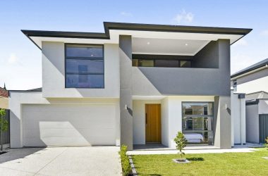 driveway view of double storey modern home with front garden and garage