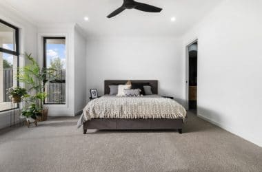 Modern master bedroom at the front of the home with front window and walk in robe